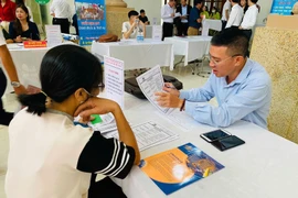 A business representative gives information to a job seeker. (Illustrative photo: VNA)