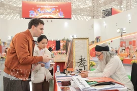 A foreign visitor to the first Glorious Spring Fair, held at the Vietnam Exposition Centre in Hanoi from February 2 to 13. (Photo: VNA)