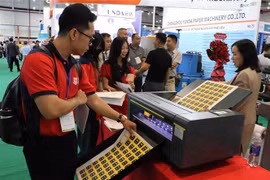 Visitors learn about stamp printing technology at the Vietnam International Paper and Packaging Exhibition 2025 (Photo: VNA)