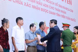 PM Pham Minh Chinh presents the announcements of martyrs' DNA testing results to representatives of families at the conference on July 25. (Photo: VNA) 