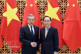 Vietnamese Politburo member and Minister of Foreign Affairs Le Hoai Trung (right) welcomes Chinese Politburo member and Minister of Foreign Affairs Wang Yi in Hanoi on March 15. (Photo: VNA)