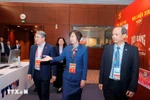 Member of the Party Central Committee and Minister of Justice Nguyen Hai Ninh (L) visits the working area of the Vietnam News Agency at the press centre of the 14th National Party Congress. (Photo: VNA)