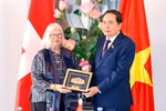 Chairman of the Vietnamese National Assembly Tran Thanh Man (R) presents a gift to President of the Switzerland–Vietnam Friendship Association Anjuska Marija Weil on July 28. (Photo: VNA)