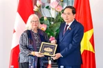 Chairman of the Vietnamese National Assembly Tran Thanh Man (R) presents a gift to President of the Switzerland–Vietnam Friendship Association Anjuska Marija Weil on July 28. (Photo: VNA)