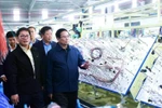 Prime Minister Pham Minh Chinh (R) visits a production line of an enterprise in Quang Nam last month. (Photo: VNA)