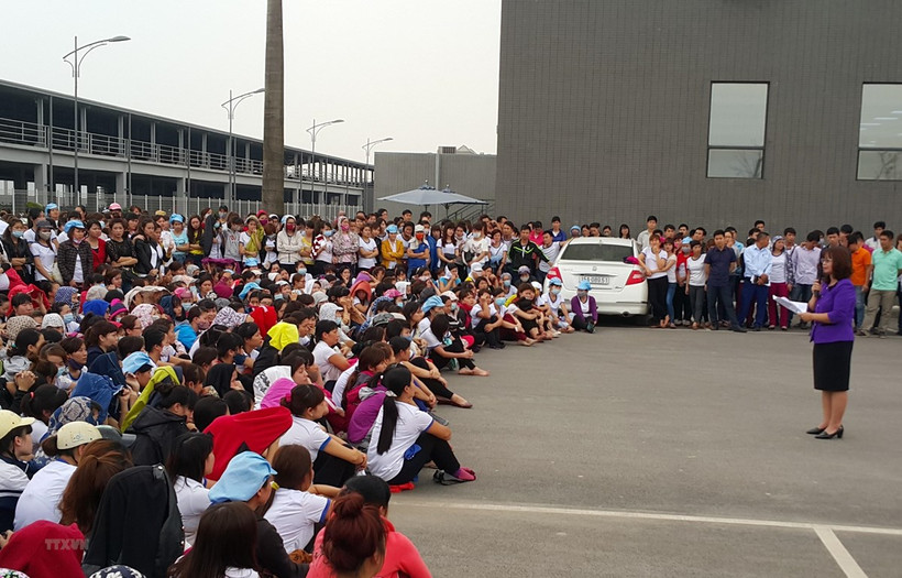 A trade union officer talk to workers. (Photo: VNA)