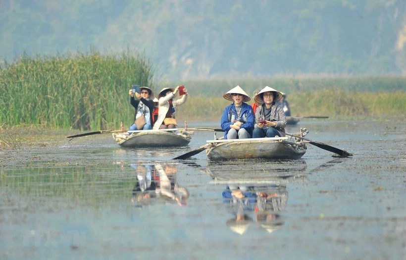 Visitors have a boat tour of Van Long Wetland Nature Reserve (Photo: VNA)