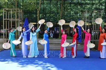 The soulful music set the stage for Vietnamese graceful women in flowing ao dai and tilted conical hats, moving with elegance. (Photo: VNA)