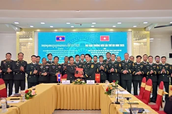 The two sides sign the minutes of the meeting. (Photo: VNA)
