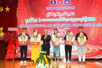 A representative of Cuu Long University presents gifts to Cambodian and Lao students. (Photo: VNA)