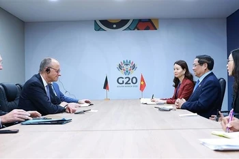 Vietnamese Prime Minister Pham Minh Chinh (second, right) and German Chancellor Friedrich Merz (second, left) at their meeting in Johannesburg on November 23. (Photo: VNA)