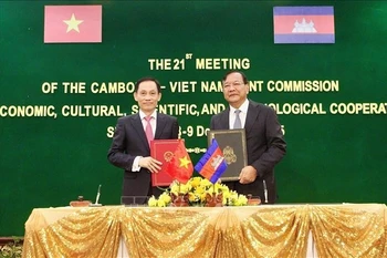 Minister of Foreign Minister Le Hoai Trung (left) and Cambodian Deputy Prime Minister and Minister of Foreign Affairs and International Cooperation Prak Sokhonn sign the minutes of the meeting. (Photo: VNA)