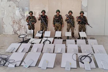 Soldiers stand next to Starlink machines as they seize KK Park online scam centre.