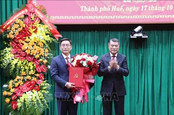 Politburo member, Secretary of the Party Central Committee, and Chairman of its Organisation Commission Le Minh Hung (R) hands overs the decision to Nguyen Dinh Trung at a ceremony on October 17, 2025 (Photo: VNA)
