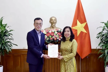Deputy Minister of Foreign Affairs Le Thi Thu Hang (right) presents the licence to Chief representative of Financial News in Vietnam Kim Kwan Woong. (Photo: MoFA)