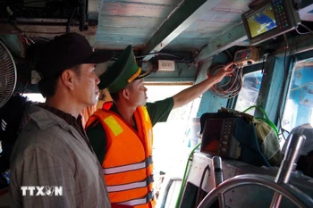 A border guard officer of Dong Thap examines the operation of the vessel monitoring system on a fishing boat. (Photo: VNA)