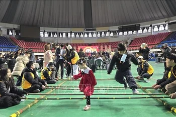 Mua sap (bamboo dancing), a traditional Vietnamese folk game, attracts many children from multicultural families to take part. (Photo: VNA)