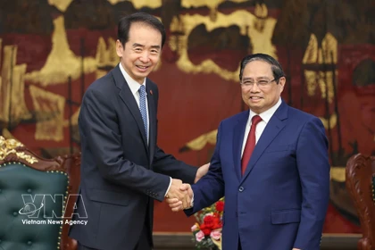 Prime Minister Pham Minh Chinh (R) hosts a reception for Chinese Ambassador to Vietnam He Wei at the Government Headquarters in Hanoi on April 5. (Photo: VNA)