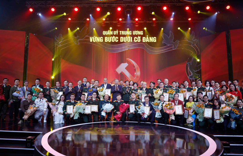 Party General Secretary To Lam and Minister of National Defence General Phan Van Giang pose for a photo with the award-winning authors and author groups. (Photo: VNA)