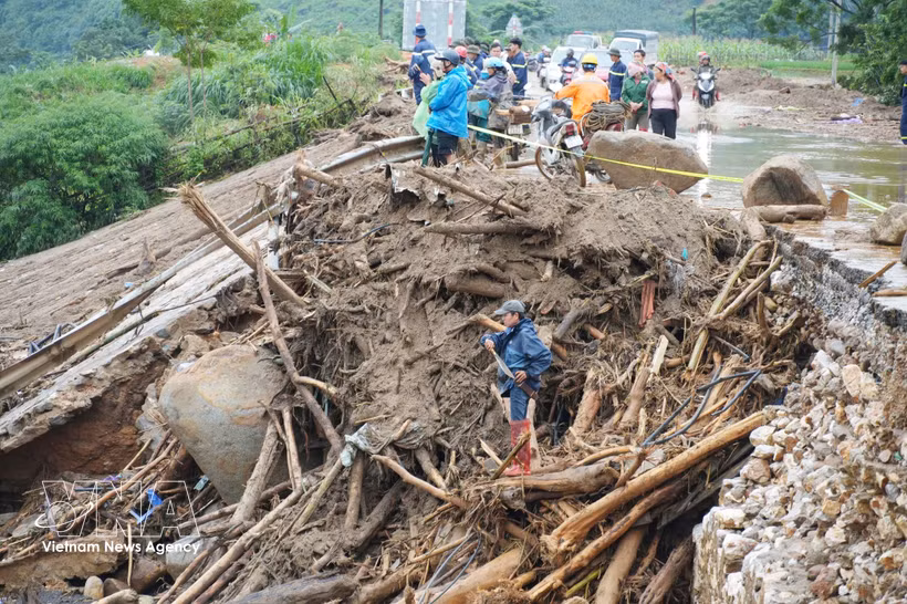 As floodwaters recede, tree branches, logs and debris blanket a road in Muong Than commune, Lai Chau province. (Photo: VNA)