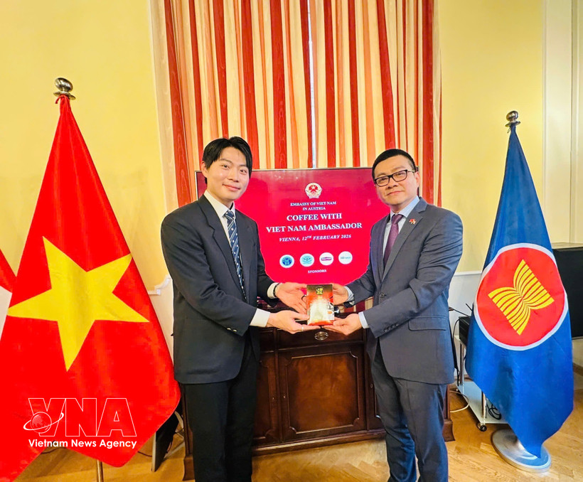 Vietnam’s Ambassador to Austria Vu Le Thai Hoang (R) presents Vietnamese coffee to an international student. (Photo: VNA)