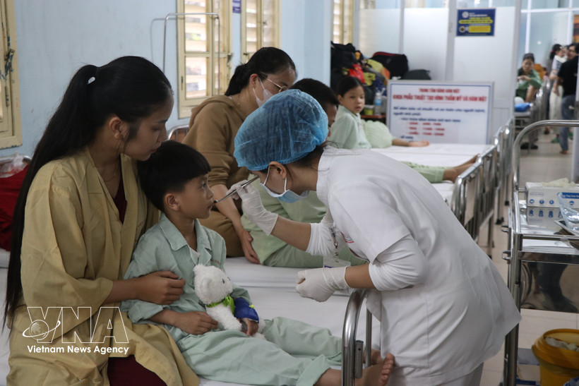 A health worker examines the surgical wound of a patient after surgery. (Photo: VNA) 
