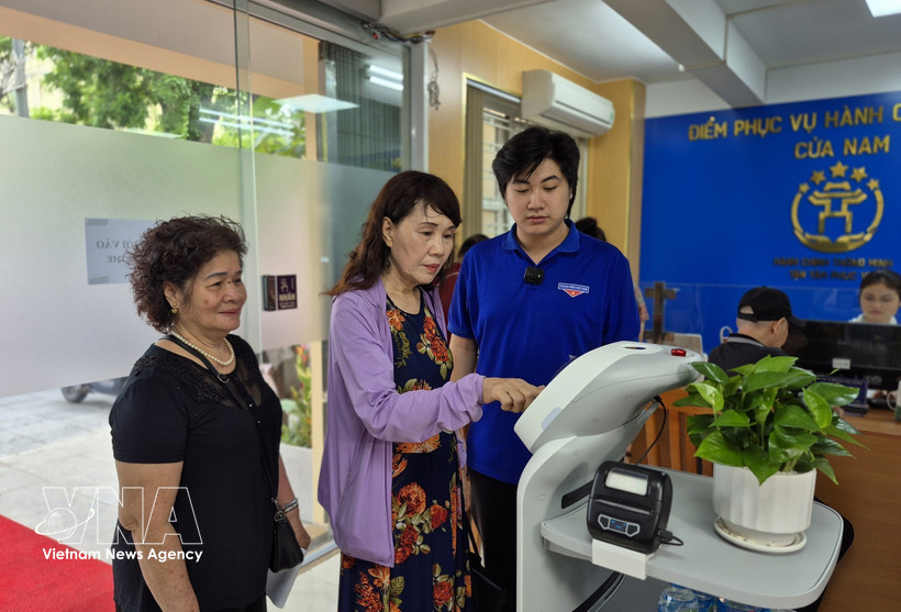 Citizens experience an AI-powered robot designed to assist with administrative procedures. (Photo: VNA)