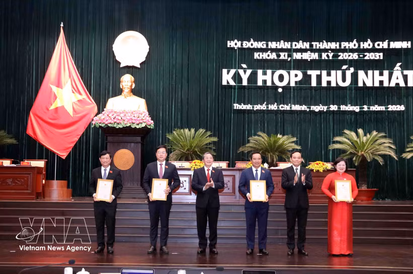 Politburo member and Secretary of the Ho Chi Minh City Party Committee Tran Luu Quang (second from right) and Vice Chairman of the National Assembly Nguyen Duc Hai (third from left) present certificates recognising members of the 11th-term Ho Chi Minh City People’s Council (2026–2031). (Photo: VNA) 