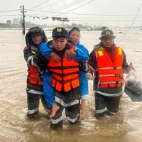 Police officers assist elderly residents in evacuating from deeply flooded areas in Dak Lak province. (Illustrative photo: VNA)
