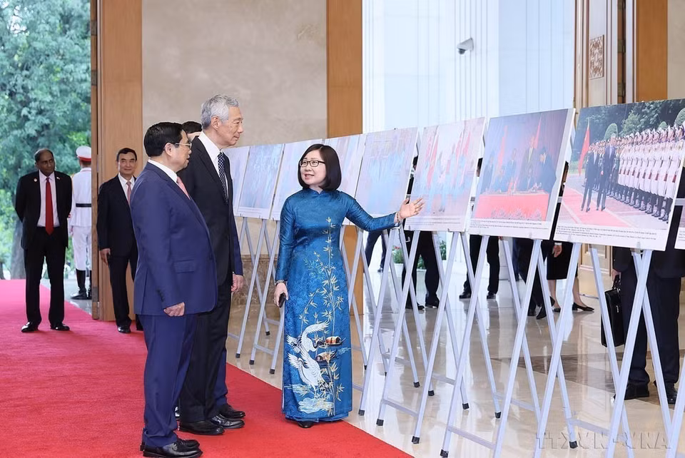 Prime Minister Pham Minh Chinh and Singaporean Prime Minister Lee Hsien Loong attend an exhibition showcasing photos highlighting 50 years of diplomatic relations and 10 years of strategic partnership between Vietnam and Singapore, organised by the Vietnam News Agency (Hanoi, August 28, 2023). (Photo: VNA)