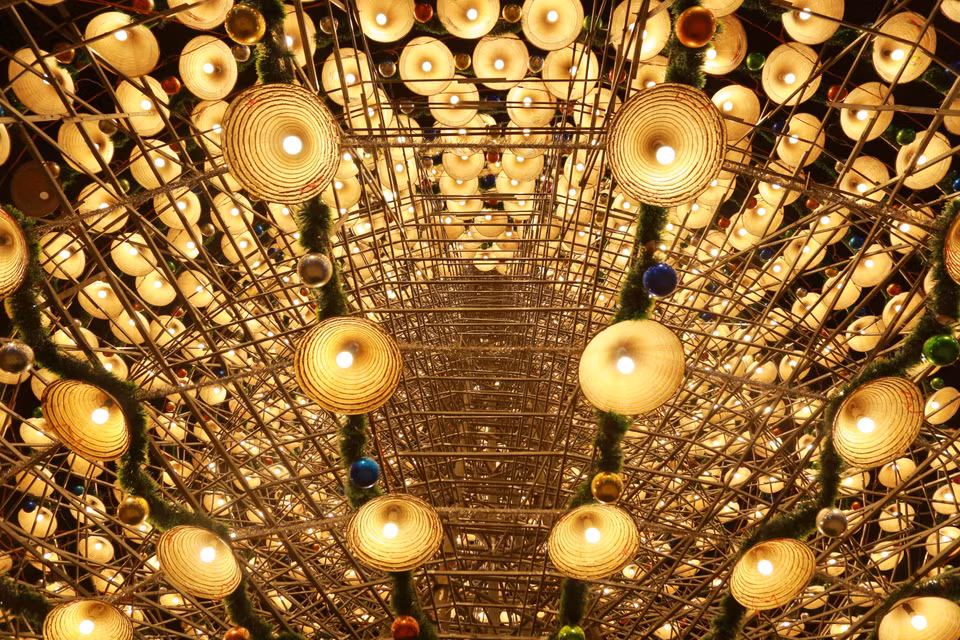 The tree is decorated with layers of conical hats, light bulbs, tinsel, and baubles, creating a mysterious and captivating beauty. (Photo: VNA)