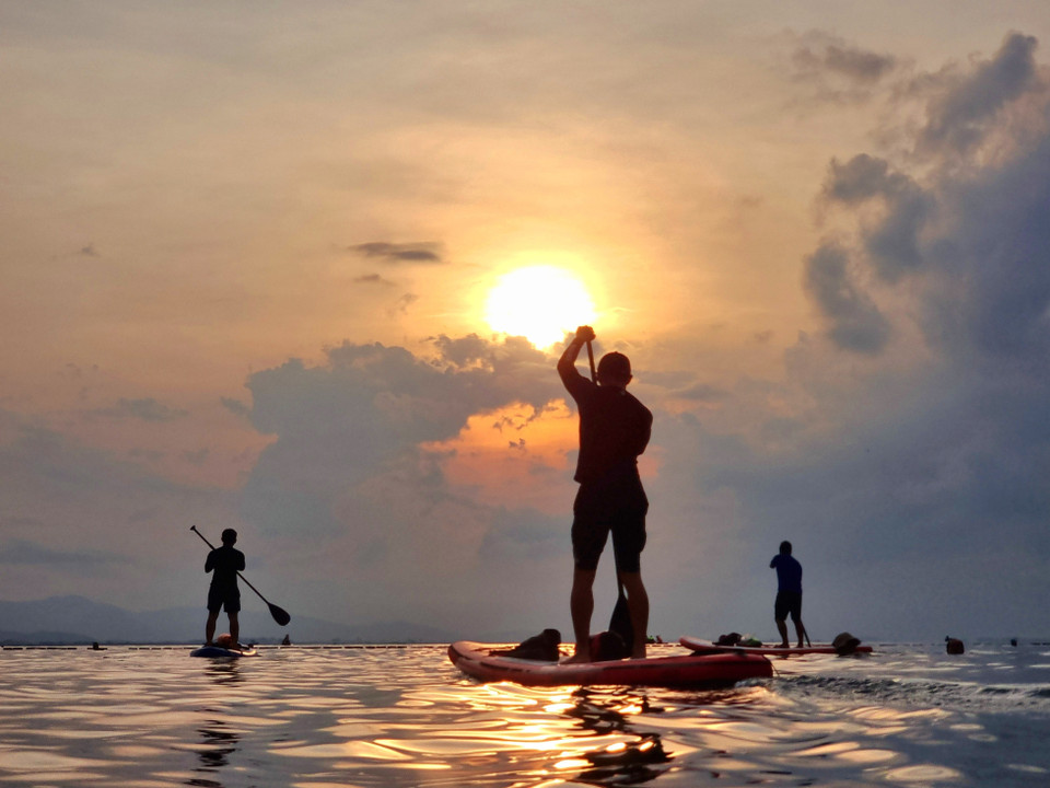 Visitors paddle SUP boards on Binh Son beach (Phan Rang – Thap Cham city) as the sun rises over the sea. (Photo: VNA)