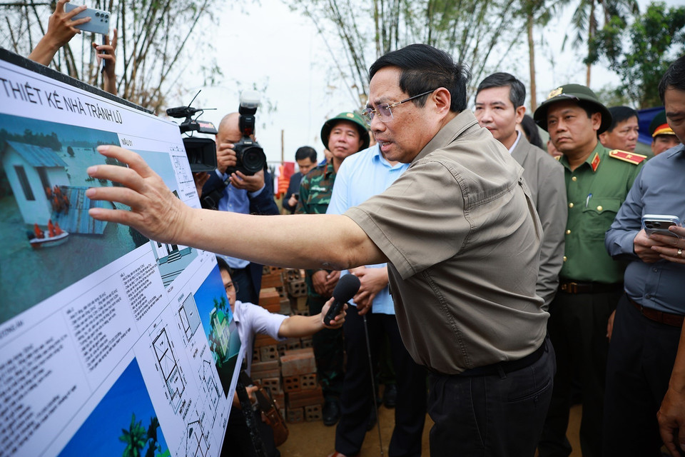 Prime Minister Pham Minh Chinh reviews the plan for building flood-resistant houses for residents in flood-affected areas. (Photo: VNA)