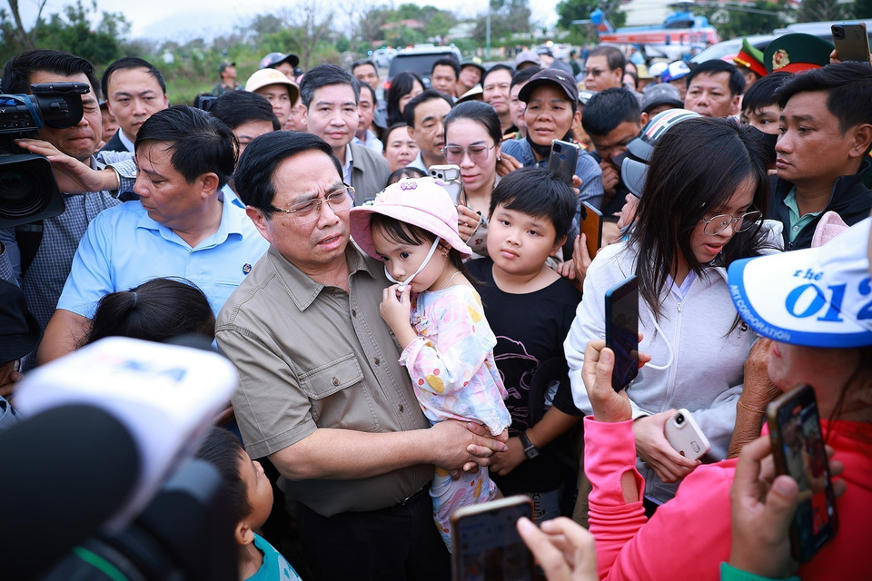 Prime Minister Pham Minh Chinh visits and encourages residents in areas severely affected by the floods in Hoa Thinh commune. (Photo: VNA)