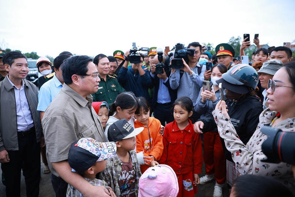 Prime Minister Pham Minh Chinh visits and encourages residents in areas severely affected by the floods in Hoa Thinh commune. (Photo: VNA)