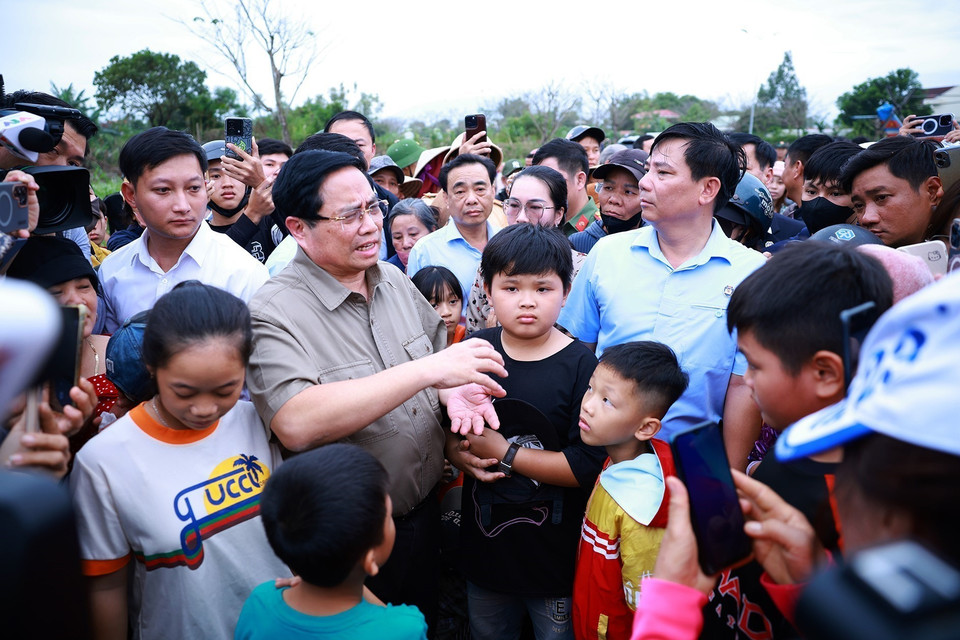 Prime Minister Pham Minh Chinh visits and encourages residents in areas severely affected by the floods in Hoa Thinh commune. (Photo: VNA)