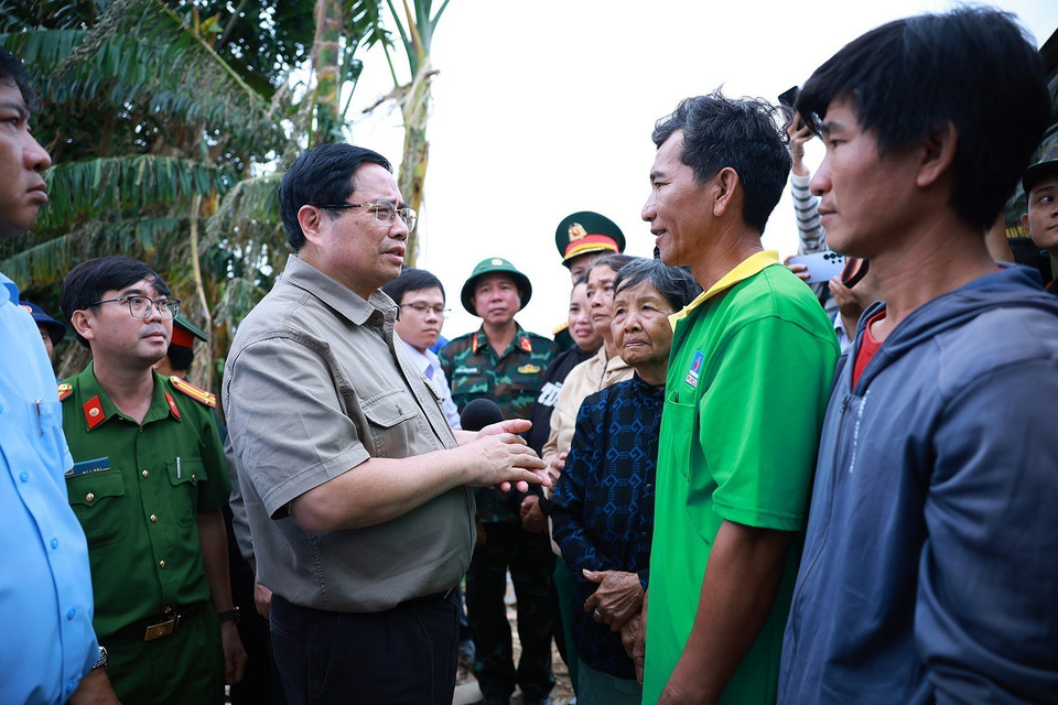 Prime Minister Pham Minh Chinh visits and encourages residents in areas severely affected by the floods in Hoa Thinh commune. (Photo: VNA)