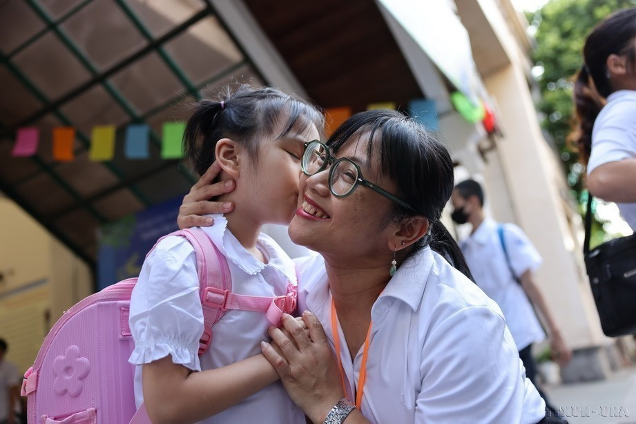 A teacher from Binh Minh Primary School (Hoan Kiem district, Hanoi) joyfully welcomes students on the first day of the 2024-2025 academic year. (Photo: VNA)