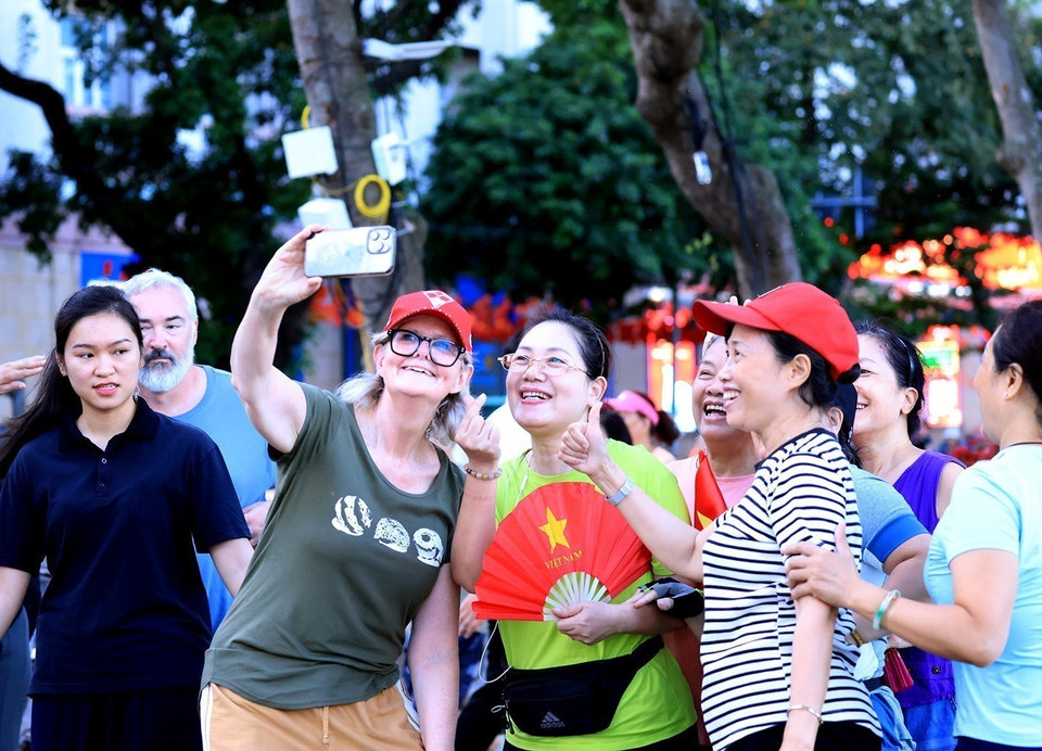 Australian Governor-General Sam Mostyn takes a selfie photo with local residents. (Photo: VNA)