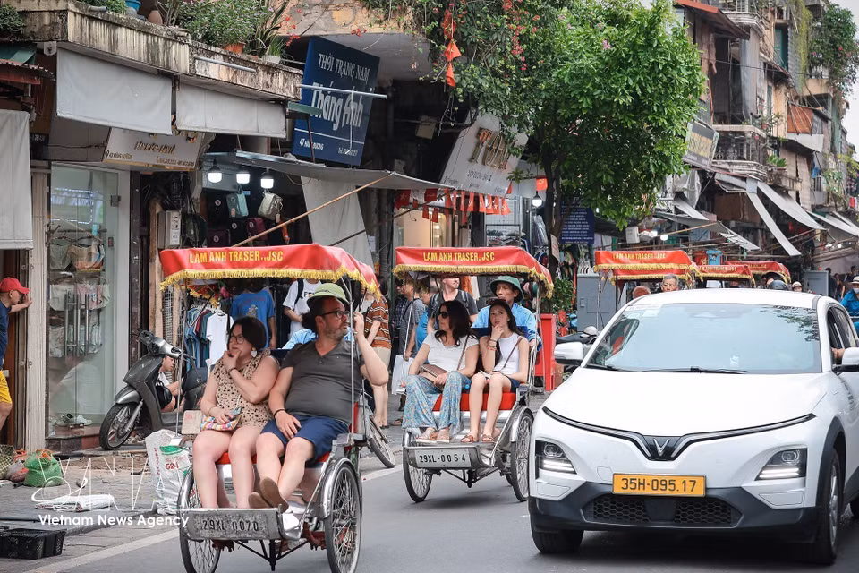 Visitors explore Hanoi's Old Quarter by cyclo, experiencing the capital's distinctive architecture and vibrant street life. (Photo: Pham Tuan Anh/VNA)