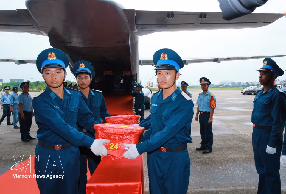 Samples taken from the remains of fallen soldiers are solemnly carried from the aircraft at Gia Lam Airport ahead of an incense-offering ceremony in their memory. (Photo: Trong Duc/VNA)
