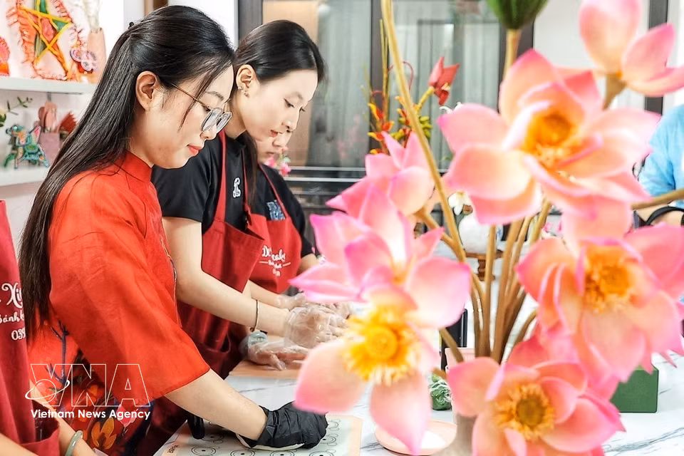 Every step of the shaping process is done entirely by hand, requiring meticulous attention to detail so that each petal, stamen, bud and stem made from tò he dough comes together in a natural and harmonious form. (Photo: Pham Tuan Anh/VNA)