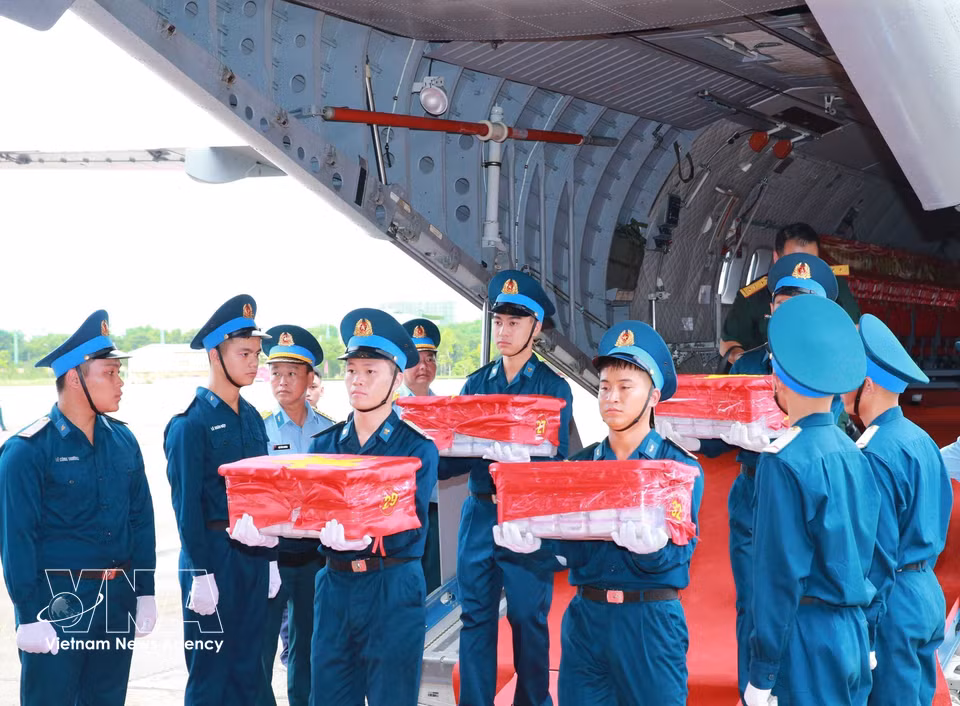 Samples taken from the remains of fallen soldiers are solemnly carried from the aircraft at Gia Lam Airport ahead of an incense-offering ceremony in their memory. (Photo: Trong Duc/VNA)