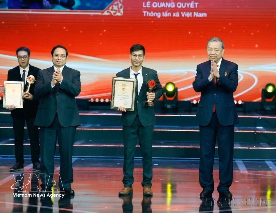 Party General Secretary To Lam and Prime Minister Pham Minh Chinh present A Prize to journalist Le Quang Quyet of the Vietnam News Agency at the 10th Golden Hammer and Sickle Awards ceremony in Hanoi on February 3, 2026. (Photo: Thong Nhat – VNA)
