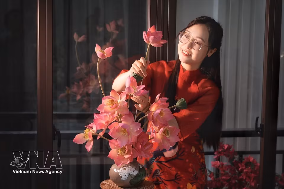 Using only edible ingredients, Thuy Duong, 31, from Hanoi, arranges the handcrafted flowers at different heights to create a layered composition that looks remarkably like a real lotus arrangement. (Photo: Pham Tuan Anh/VNA)