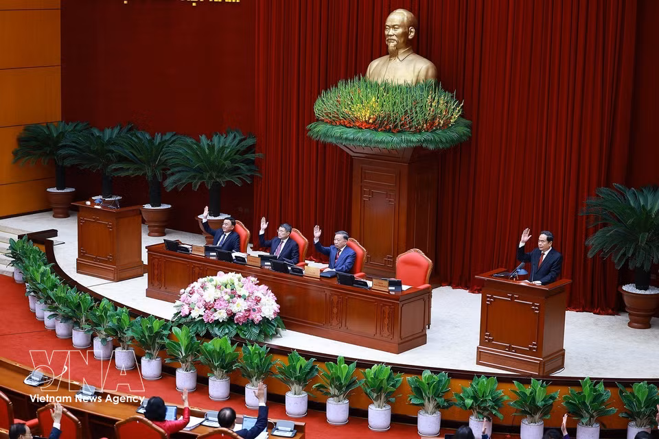 Delegates vote to adopt the agenda of the third meeting of the 14th Party Central Committee. (Photo: Duong Giang/VNA)