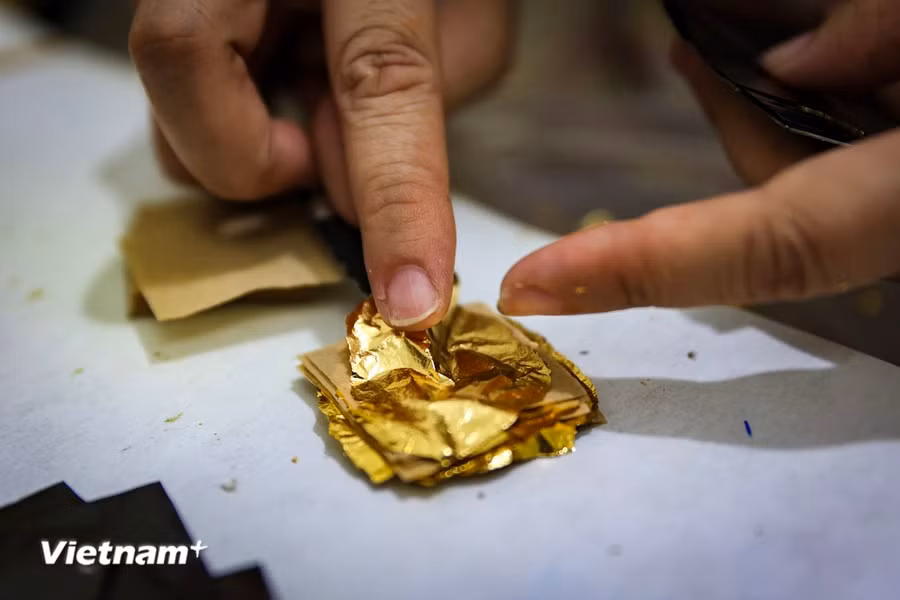 The processes of arranging the gold in preparation for the hammering and creating the old gold leaf require high levels of patience and precision. (Photo: Vietnam+)