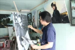 Artist Tran Hoa Binh paints a portrait of President Ho Chi Minh. (Photo: VNA)