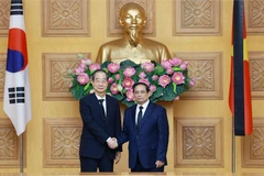 Prime Minister Pham Minh Chinh (R) hosts a reception for his Korean counterpart Han Duck Soo. (Photo: VNA)