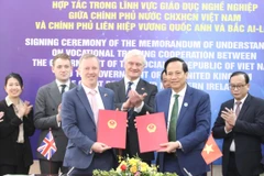 Vietnamese Minister of Labour, War Invalids and Social Affairs Dao Ngoc Dung (right) and British Ambassador to Vietnam Gareth Ward pose for a photo after signing the Memorandum of Understanding on vocational training cooperation between Vietnam and the UK